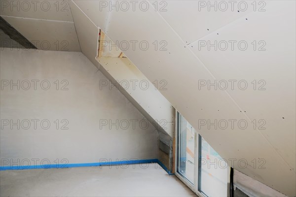 Attic conversion, loft conversion. You can see the pitched roof with door and skylight panelled with plasterboard