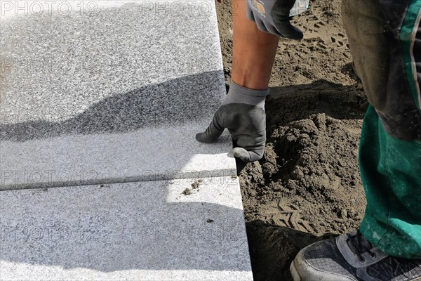 Worker lays paving stones