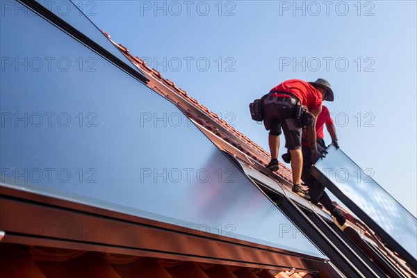 Installation of solar collectors for solar thermal energy. The company Hanschke Solarmontagen installs solar panels on a newly built apartment block in Mutterstadt (Palatinate)