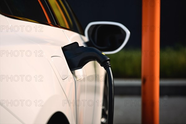 White electric car with charger. KI generiert, generiert AI generated