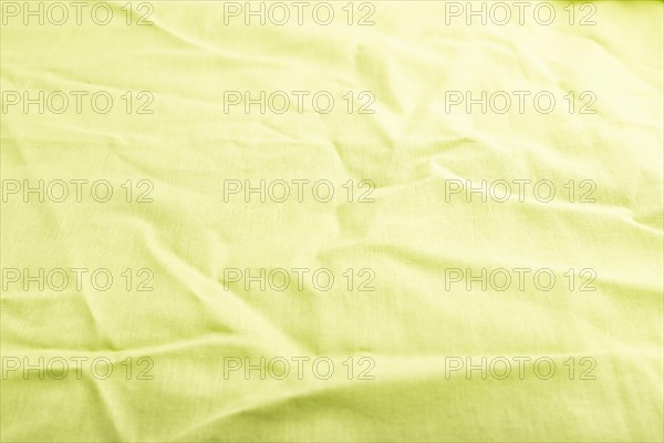 Fragment of smooth green linen tissue. Side view, natural textile background and texture
