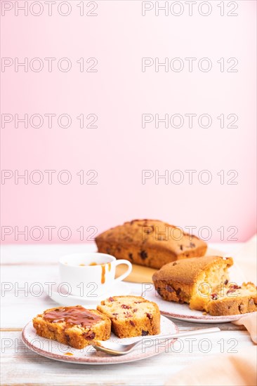 Homemade cake with raisins, almonds, soft caramel on a white and pink background. Side view, selective focus, copy space