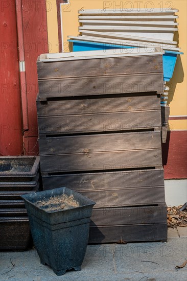 Disused wooden and plastic planter boxes outdoors against wall of building in South Korea