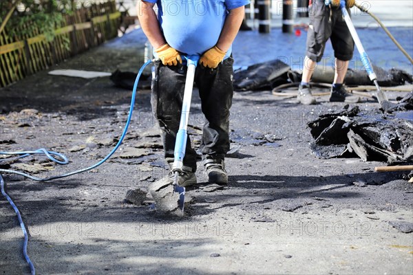 Roofers remove old bitumen and roof waterproofing