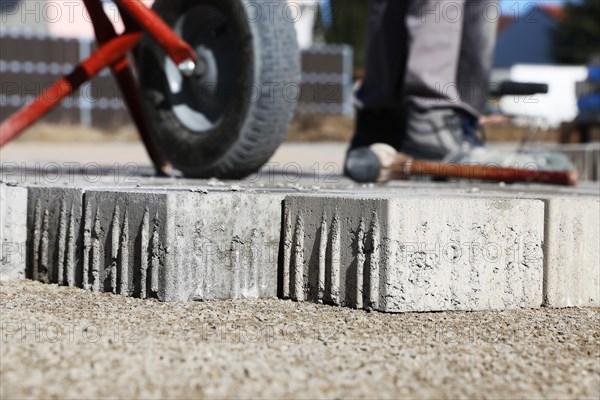 Workers lay paving stones