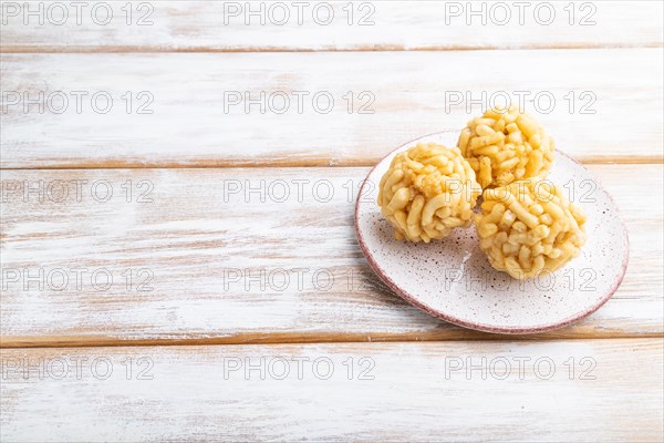 Traditional Tatar candy chak-chak made of dough and honey on a white wooden background. Side view, copy space, close up