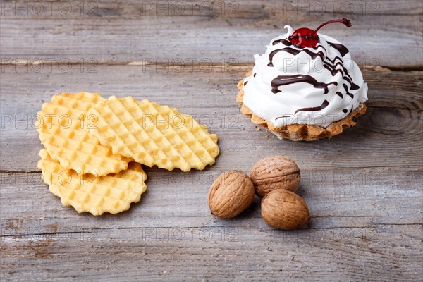 Sweet waffle and a cake with cream on a rustic wooden background with copy space