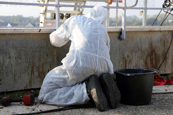 Professional asbestos removal by workers in protective suits