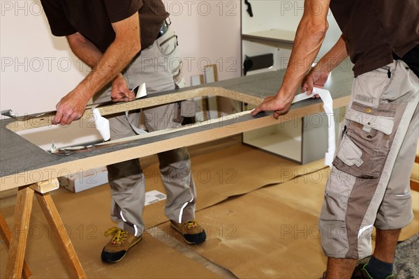 Craftsmen installing a new kitchen (kitchen assembly)