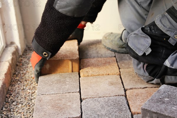 Worker lays paving stones