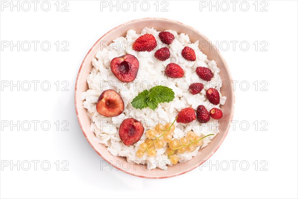 Rice flakes porridge with milk and strawberry in ceramic bowl isolated on white background. Top view, flat lay, close up