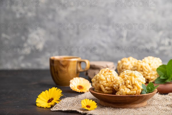 Traditional Tatar candy chak-chak made of dough and honey with cup of coffee on a black concrete background and linen textile. Side view, close up, selective focus, copy space
