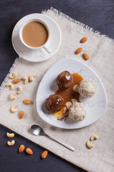 Energy balls cakes with chocolate caramel and coconut on white plate on linen napkin, top view