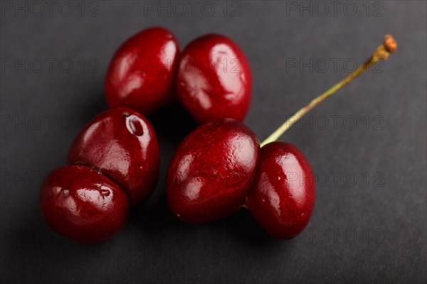 Ugly weird red sweet cherry on black background. side view, close up, macro, trendy