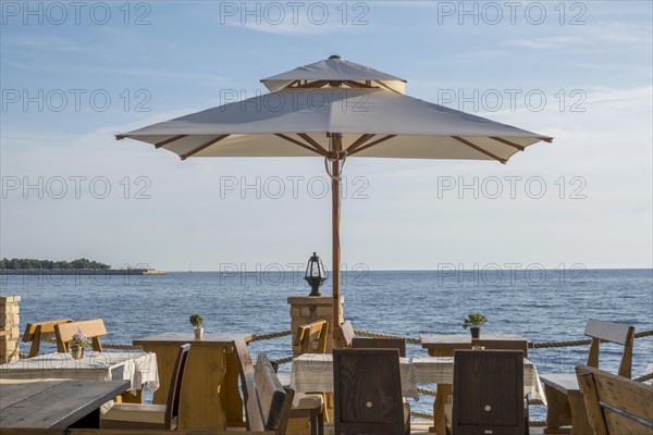 Tables in a restaurant by the sea, Umag, Istria, Croatia, Europe