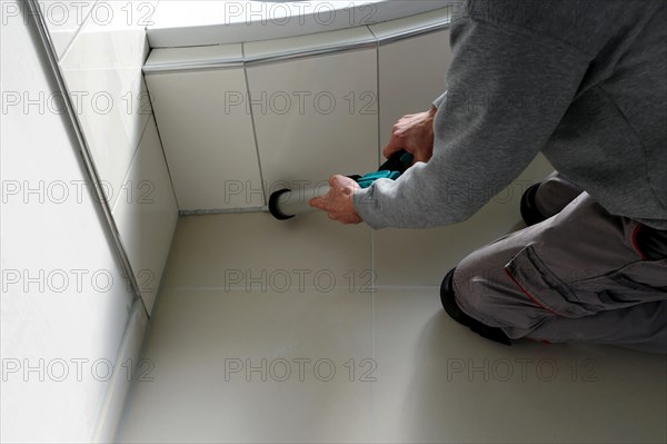 Grouting work. Tiler grouting in a new bathroom