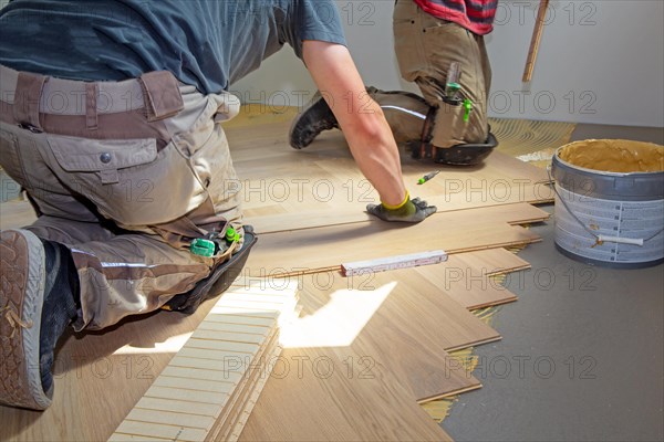 Craftsmen laying herringbone parquet professionally