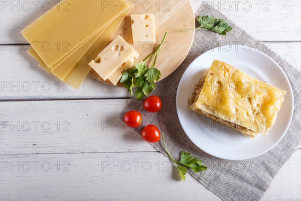 Lasagna with minced meat and cheese on white wooden background. copy space, top view