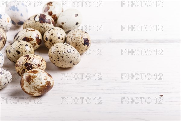 Raw quail eggs on a white wooden background. with copy space