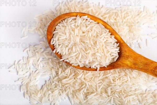 Pile of basmati rice in a wooden spoon isolated on white background