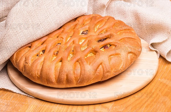 Sweet buns on a wooden board and linen tablecloth