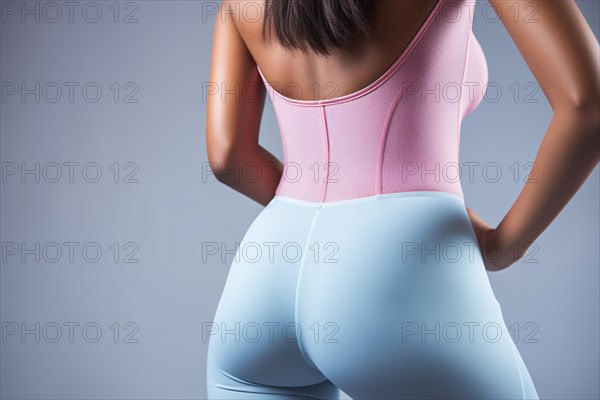 Woman's defined buttocks in workout sport pants in front of studio background. KI generiert, generiert AI generated