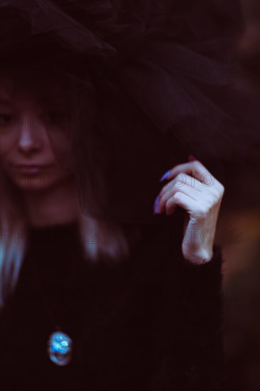 Close-up of a woman in soft focus with tulle fabric, set against a dark theme with subtle colors