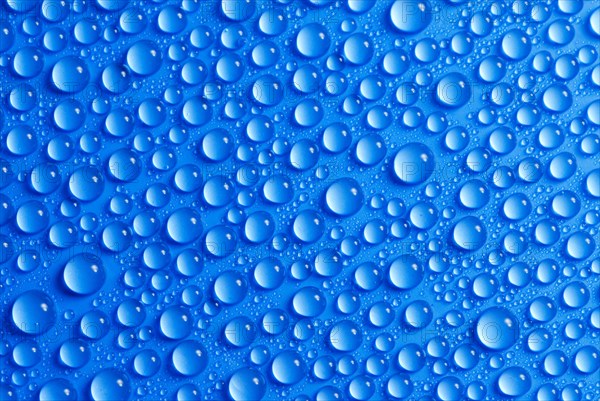 Many small water drops on a blue surface