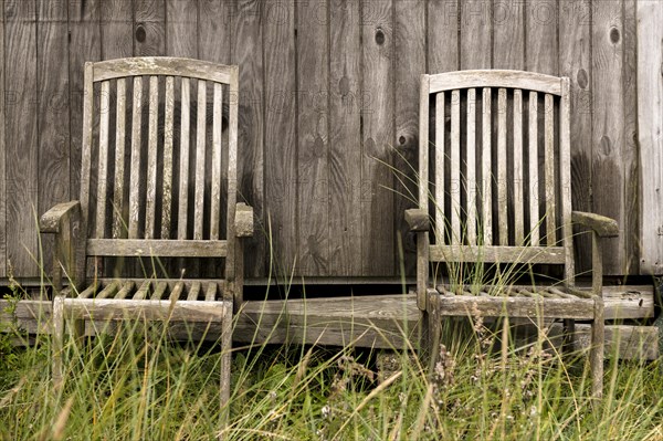 2 wooden chairs in front of a natural wooden wall of a fisherman's hut, Hvide Sande, Midtjylland region, Denmark, Europe