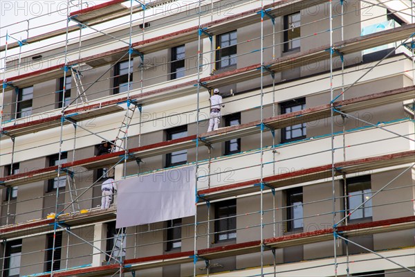 Painter painting the facade of a new apartment building