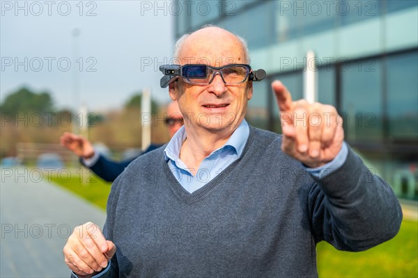 Aged businessman using mixed reality glasses during a guided operation from outside country