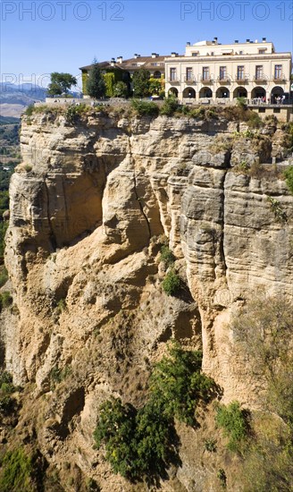 Historic National Parador hotel building perched on sheer cliff top in Ronda, Spain, Europe