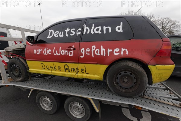 Accident car painted in Germany colours, with the inscription Deutschland vor den Wand gefahren, farmers' protests, demonstration against the policy of the traffic light government, abolition of agricultural diesel subsidies, Duesseldorf, North Rhine-Westphalia, Germany, Europe