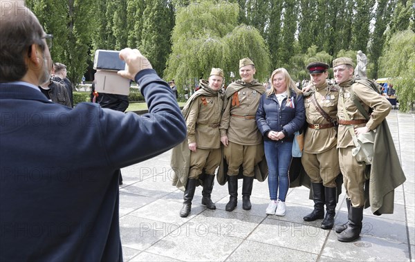 Men in Russian uniforms take a group photo at the Soviet memorial in Treptow Park to mark the 74th anniversary of Russia's victory over Germany, 09.05.2019