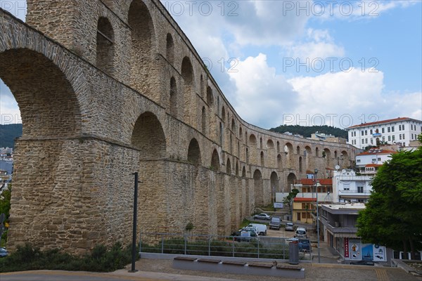 A Roman aqueduct spans a modern cityscape under a cloudy sky, Kavala, Dimos Kavalas, Eastern Macedonia and Thrace, Gulf of Thasos, Gulf of Kavala, Thracian Sea, Greece, Europe