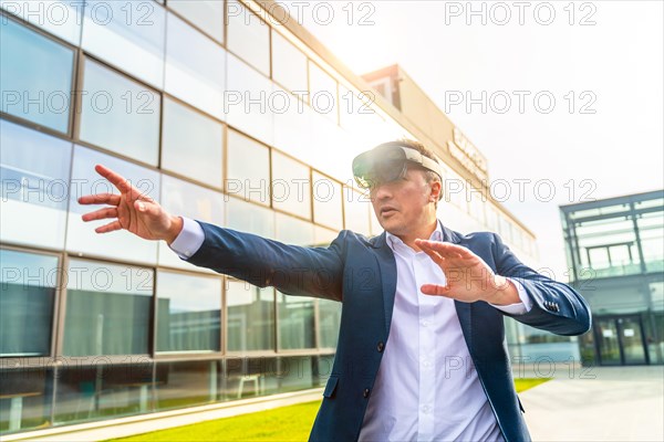 Businessman wearing virtual reality simulator outside the offices in a sunny day