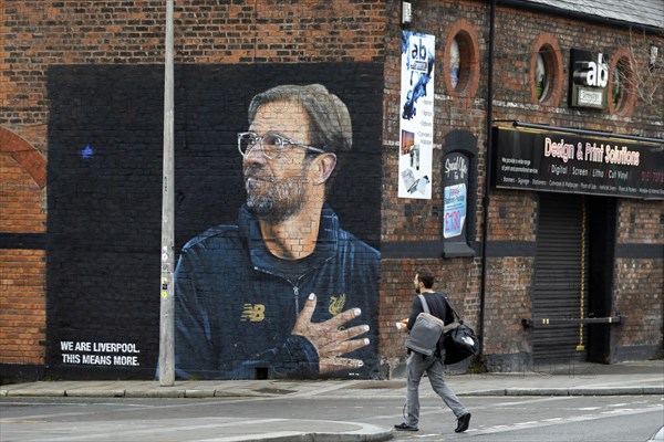 A large poster with a picture of Juegen Klopp, the coach of Liverpool FC, and the slogan We are Liverpool, this means more, hangs on the wall of a building in Liverpool's Baltic Triangle district, 01/03/2019