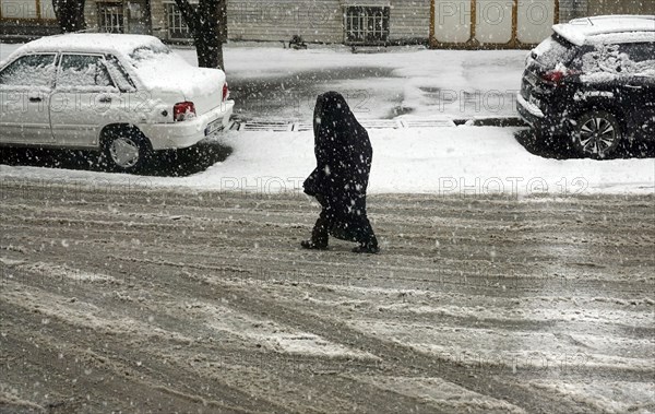 Heavy snowfall in Arak, Iran, woman with chador and traditional clothing, 16/03/2019, Asia