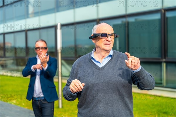 Businessman experiencing with augmented mixed vision headset in an urban park next to financial building