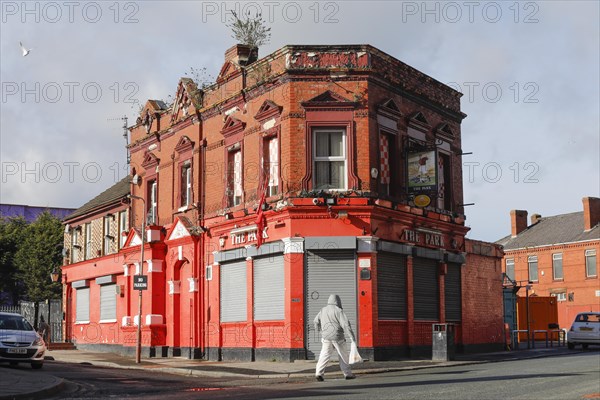 A man walks past a house near Liverpool FC's Anfield football stadium, 02/03/2019