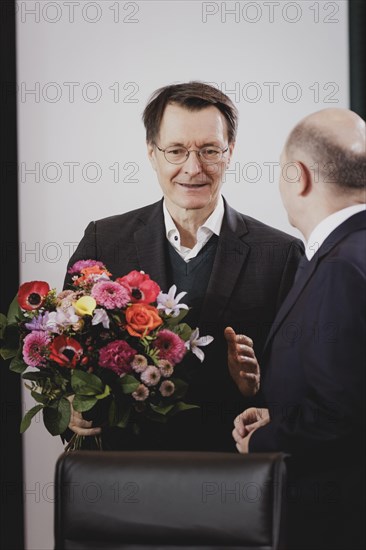 (L-R) Karl Lauterbach (SPD), Federal Minister of Health, and Olaf Scholz (SPD), Federal Chancellor, pictured during the weekly cabinet meeting in Berlin, 21 February 2024. Lauterbach receives the flowers from the Federal Chancellor on his birthday