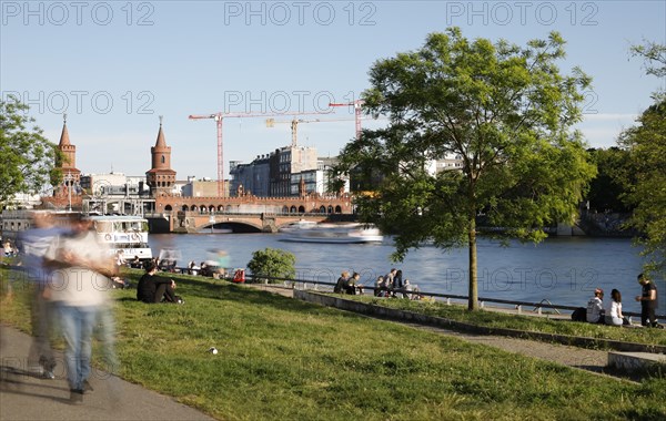 Long exposure shows walkers and people on the banks of the Spree, Berlin, 05/05/2018