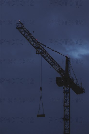 A crane works at blue hour in Berlin, 20/02/2024