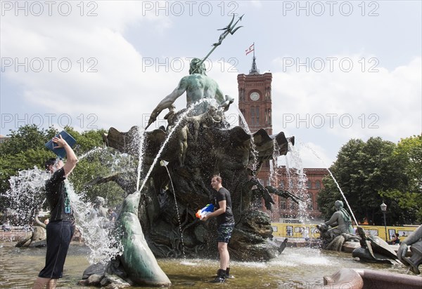 Water-hungry participants of this year's water fight at Berlin's Neptune Fountain cool off in summer temperatures on 17 June 2018. Buckets and large water pistols are ideal helpers for getting each other wet