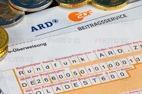 Symbolic image of the licence fee, contribution service: Close-up of a letterhead with ARD logo and ZDF logo and a remittance slip and coins