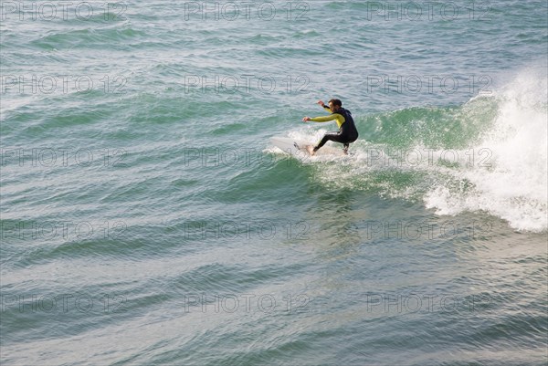 Young man wearing wet-suit surfing in Cornwall, England, United Kingdom, Europe