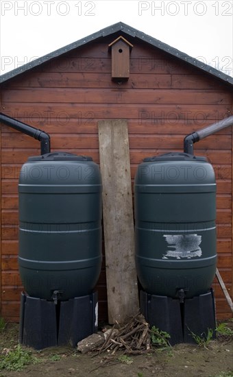 Two water butts illustrating concept of watershed dividing drainage basins on roof
