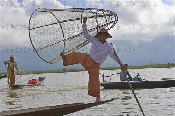 Intha fisherman, local man fishing with traditional conical fishing net, Inle Lake, Burma, Myanmar, Asia