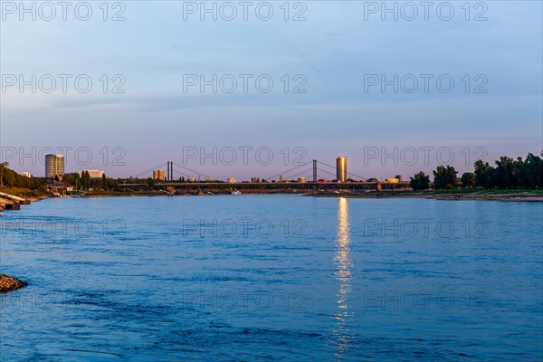 City view with bridge over a river reflecting the light of dusk, Theodor-Heuss-Bruecke, Duesseldorf, North Rhine-Westphalia