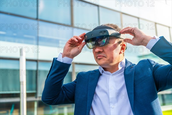 Close-up with copy space of a serious businessman using a virtual reality headset outside a modern office complex